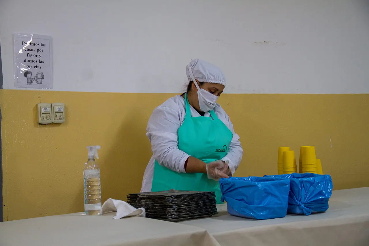 Personal de SASA preparando bandejas para el servicio en un comedor