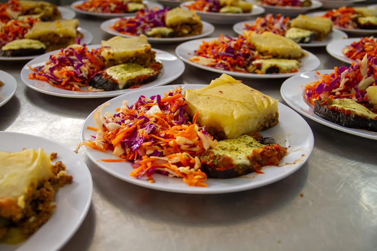 Platos de comida elaborada con pastel de papa, berenjena y ensalada
